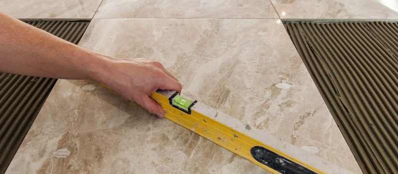 Ceramic tiles and tools for tiler. Floor tiles installation. Home improvement, renovation - ceramic tile floor adhesive, mortar, level